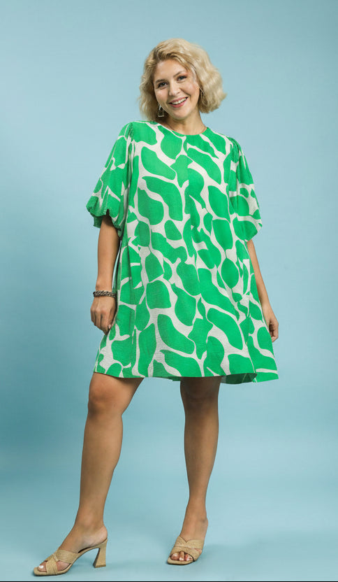 Woman wearing a green and white patterned dress on a blue background
