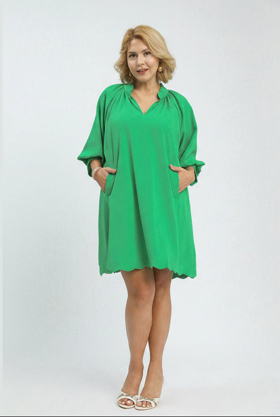 Woman wearing a green dress with a plain background