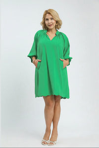 Woman wearing a green dress with a plain background