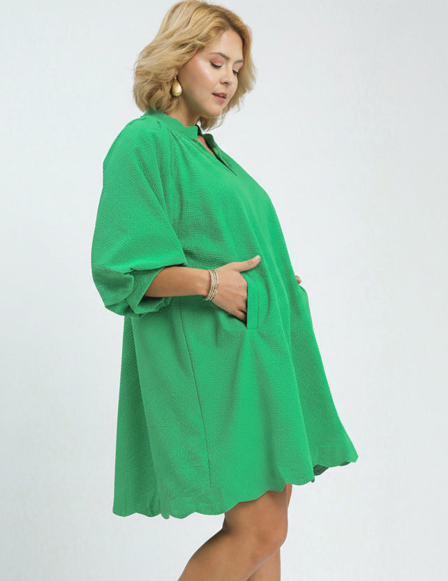 Woman wearing a green plus-size dress on a white background