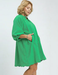Woman wearing a green plus-size dress on a white background
