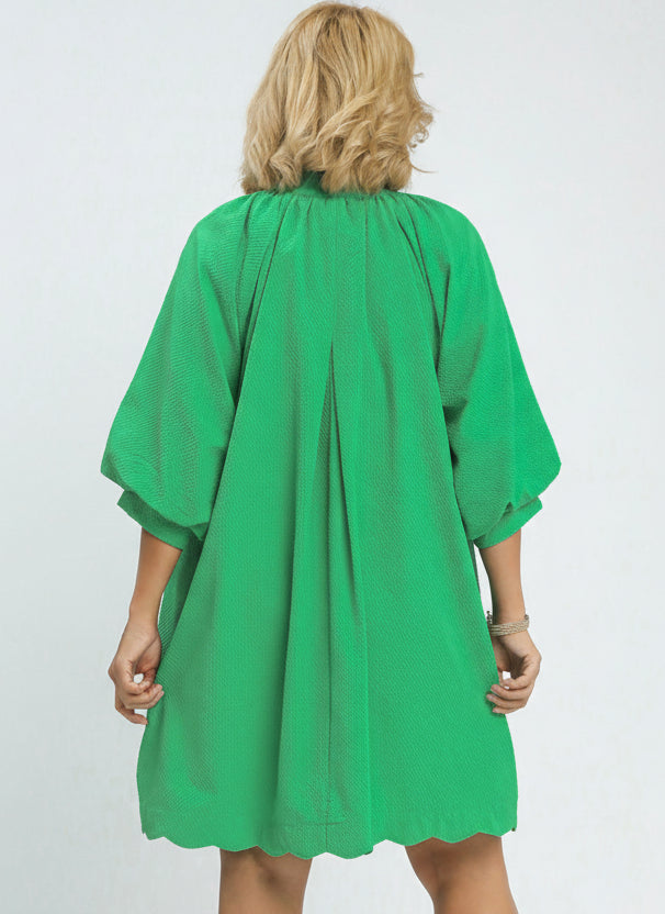 Green dress worn by a model on a white background.