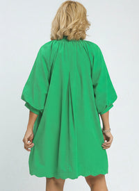 Green dress worn by a model on a white background.