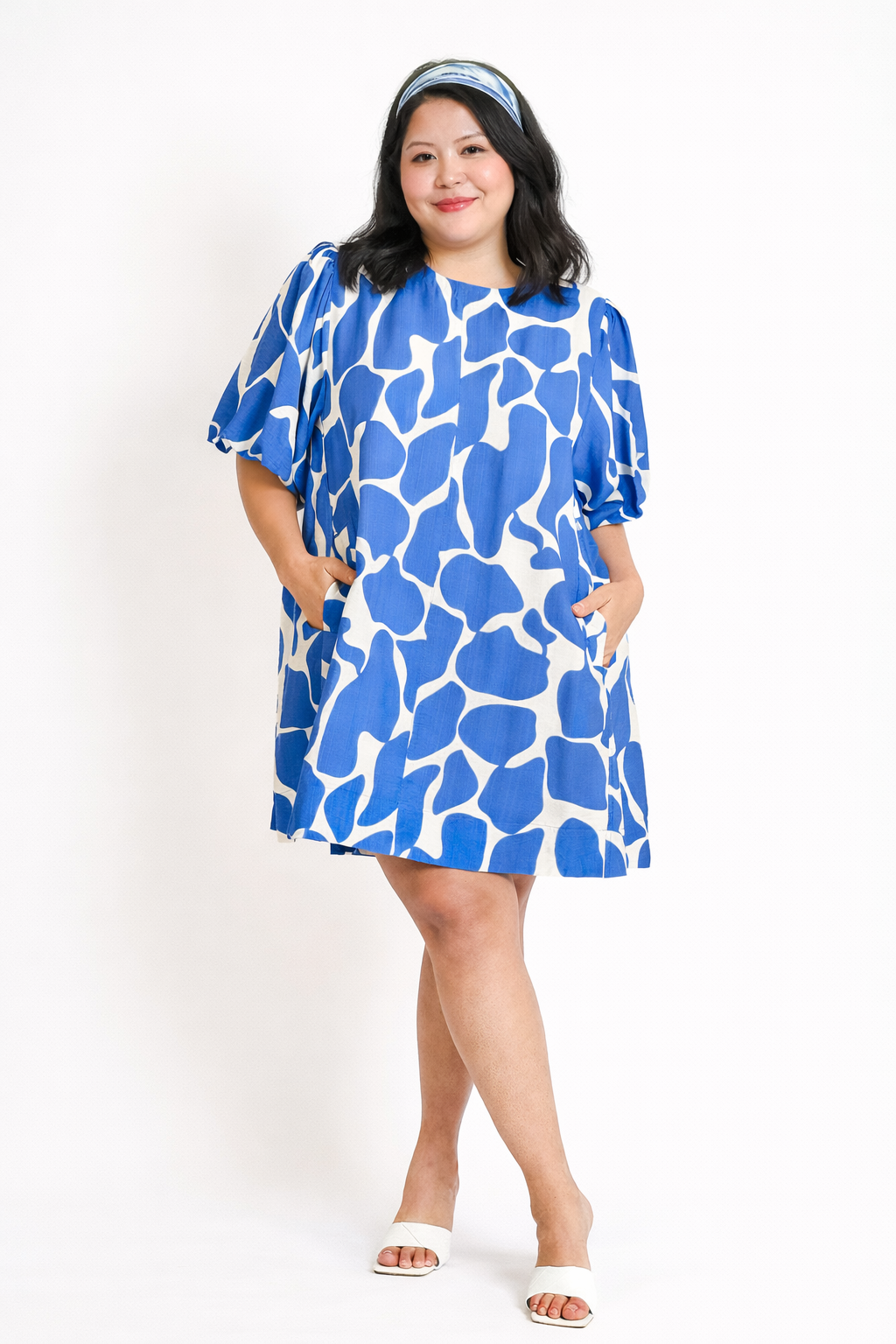 Woman wearing a blue patterned dress on a white background