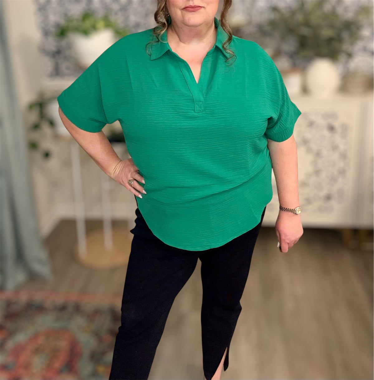 Person wearing a green shirt and black pants in an indoor setting