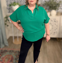 Person wearing a green shirt and black pants in an indoor setting
